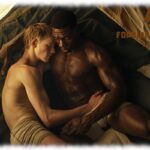 Zwei Twinks umarmen sich im Zelt liegend, die Hände suchen den lustvollen Hügel des jeweils anderen,