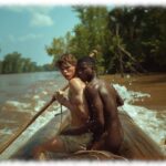 Zwei Twinks auf Boot rudernd, nackter Twink greift nach der Ungeduld im Schritt des anderen.