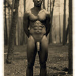 Vintage-Dunkelhäutiger Mann im Wald, Frontal, Hände auf Rücken, prächtiges Juwel der Liebe hängt nach unten.