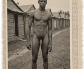 Vintage-Poster, Young Buck, dunkelhäutige Mann vor Elendshütten stehend, nackt. Vintage-Poster, Young Buck, dunkelhäutige Mann vor Elendshütten stehend, nackt.