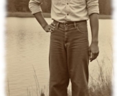 Vintage-Dunkelhäutiger Mann am See, eine Hand an der Hüfte, barfuß. Vintage-Dunkelhäutiger Mann am See, eine Hand an der Hüfte, barfuß.