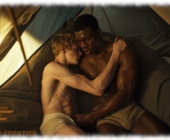 Zwei Twinks umarmen sich im Zelt liegend, Hand an der leichte Auswölbung des anderen, Zwei Twinks umarmen sich im Zelt liegend, Hand an der leichte Auswölbung des anderen,