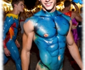 Blonder Twink, blau angemalt beim Straßen-Karneval, rasiertes Juwel der Liebe sichtbar. Blonder Twink, blau angemalt beim Straßen-Karneval, rasiertes Juwel der Liebe sichtbar.