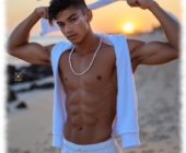 Twink am Strand stehend. Hände über dem Kopf, freier Oberkörper. Twink am Strand stehend. Hände über dem Kopf, freier Oberkörper.