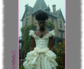 Dunkelhäutiger Mann in eng geschnürtem weißen Kleid, vor Villa stehend. Dunkelhäutiger Mann in eng geschnürtem weißen Kleid, vor Villa stehend.