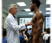 Nackter Dunkelhäutiger bei Vorlesung, Wissenschaftler berührt die Brist. Nackter Dunkelhäutiger bei Vorlesung, Wissenschaftler berührt die Brist.