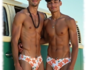 Zwei junge Männer an VW-Bus angelehnt umarmen sich, Slips mit Spannung im Stoff. Zwei junge Männer an VW-Bus angelehnt umarmen sich, Slips mit Spannung im Stoff.