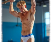 Blonder junger Mann in Sporthalle am Reck, weiße Shorts mit verräterischer Wölbung. Blonder junger Mann in Sporthalle am Reck, weiße Shorts mit verräterischer Wölbung.