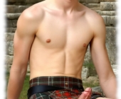 Junger Mann sitzend, rot-schwarzer Kilt macht Platz für sein aufgerichtetes Verlangen. Junger Mann sitzend, rot-schwarzer Kilt macht Platz für sein aufgerichtetes Verlangen.